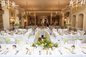 バーミンガムにあるBest Western Plough and Harrow Hotelの白いテーブルと白い椅子が備わる宴会場