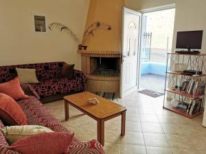 a living room with a couch and a fireplace at Amazing house Erato in front of the Sea - South Creta in Paránimfoi