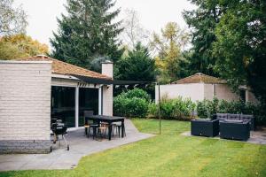 a patio with a table and chairs and a grill at COSY Holiday Home in Harderwijk