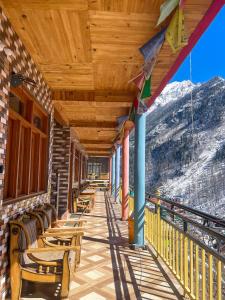 a porch with chairs and a view of a mountain at Pahadi Bliss Hostel ,Tosh in Tosh