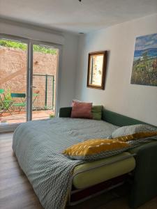 een slaapkamer met een bed en uitzicht op een patio bij Studio jardin 5 mn plage Monaco Air Conditioner in Beausoleil