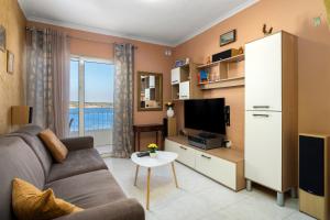 sala de estar con sofá y TV en Cosy1 Bedroom Apartment with Balcony & Sea Views - Close to Mellieha Bay, en Mellieħa