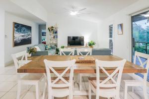 a dining room with a wooden table and white chairs at Beach home in the heart of Agnes in Agnes Water