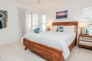 a bedroom with a large wooden bed and a window at Beach home in the heart of Agnes in Agnes Water