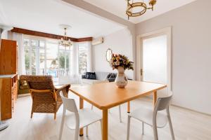 a dining room with a table with chairs and a vase with flowers at Sea View Retreat in Buyukada 1 min to Ferry in Istanbul