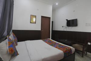 Habitación de hotel con cama y TV en FabExpress Samira Residency, Near Botanical Garden, en Noida