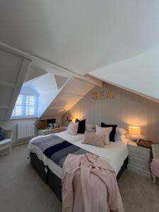 a bedroom with a large bed with a sea sign on the wall at Efail Fach in New Quay