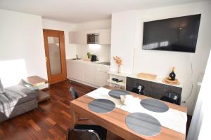 a living room with a table and a kitchen at T&B MOUNTAIN VIEW in Monguelfo