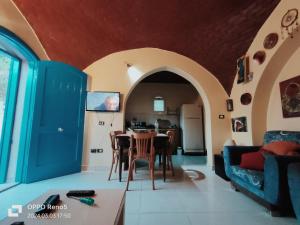 Touha House في الفيوم: غرفة معيشة مع طاولة وأريكة زرقاء