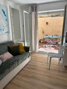 een woonkamer met een bank en een tafel bij Studio jardin 5 mn plage Monaco Air Conditioner in Beausoleil