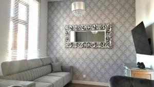 a living room with a couch and a mirror at APARTAMENT JARACZA 28/8 in Słupsk