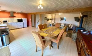 ein Esszimmer mit Tisch und ein Wohnzimmer in der Unterkunft Revival Ranch Ferienwohnung in Büllingen