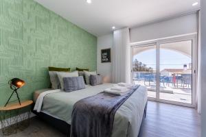 um quarto com uma cama grande e uma janela grande em Malpique Guest House & Jacuzzi em Albufeira