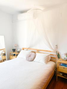 een slaapkamer met een wit bed en een roze kussen bij Penthouse Oceaview Apartment in Cala del Moral