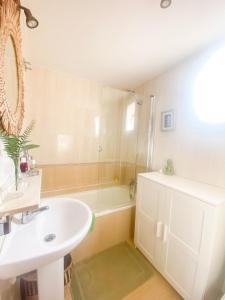 een witte badkamer met een wastafel en een douche bij Penthouse Oceaview Apartment in Cala del Moral
