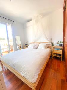 een slaapkamer met een groot bed met witte lakens bij Penthouse Oceaview Apartment in Cala del Moral