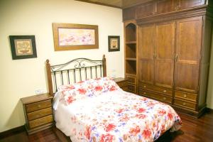 a bedroom with a bed and a wooden cabinet at 4 bedrooms house with private pool jacuzzi and enclosed garden at Magan in Cuntis