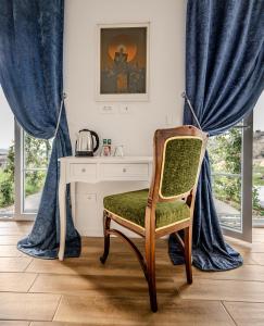 a desk and a chair in a room with blue curtains at Peterc Vineyard Estate in Kojsko