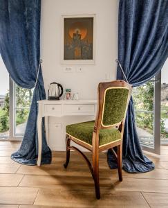 escritorio y silla en una habitación con cortinas azules en Peterc Vineyard Estate, en Kojsko