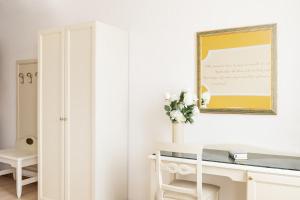 Hotel Ca' Tron في دولو: غرفة بيضاء مع مكتب ومرآة
