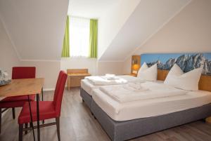 a bedroom with a bed and a desk and a table at Burghotel Aschau in Aschau im Chiemgau