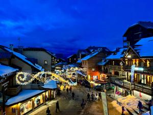 a town with christmas lights and people walking in the street at L'ETERLOU, Studio Centre station in Risoul +2 photos