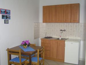 a small kitchen with a table and a sink at Apartments Paloma blanca 1 in Medulin +11 photos