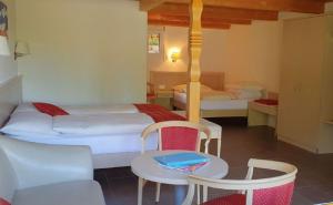 1 dormitorio con 1 cama, mesa y sillas en Chalet-Gafri - BnB - Frühstückspension - Service fast wie im Hotel, en Wilderswil