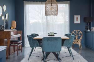 a dining room with blue walls and a table and chairs at Pleasant Family house with swimming pool in Bordeaux