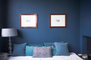 a blue wall with two pictures above a couch at Pleasant Family house with swimming pool in Bordeaux