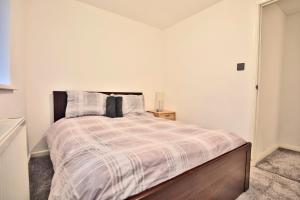 a bedroom with a bed with a striped comforter at Butlers Meadow House, Sleeps 5, near Blackpool Tower, BAE System, Free Parking - by NMB Property in Weeton