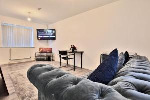 a living room with a couch and a flat screen tv at Butlers Meadow House, Sleeps 5, near Blackpool Tower, BAE System, Free Parking - by NMB Property in Weeton