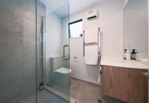 y baño con ducha, aseo y lavamanos. en Charming Retreat in the Heart of Christchurch City-CBD, 
