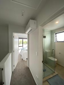 a bathroom with a glass shower and a bedroom at Charming Retreat in the Heart of Christchurch City-CBD 