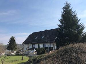 a house with a black roof on a hill at Ferienwohnung Fischer Reif 