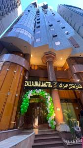 a building with a sign on it with green balloons at ظلال النزلاء in Jarwal