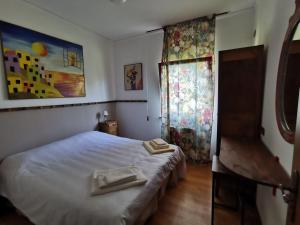een slaapkamer met een bed en een raam met handdoeken erop bij Gioz87 in Gioz