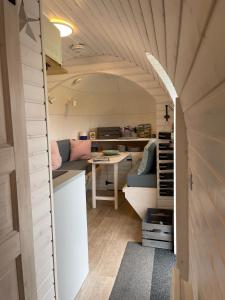 a small kitchen in a tiny house with a table at Clotted Cream -Lydcott Glamping, Cornish Sea Views in Looe