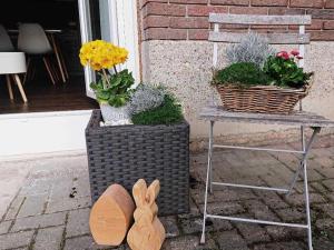 un banco con una mesa con plantas y estatuas de conejo en Ferien im Heckenland, en Kenzingen