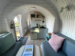 a small kitchen with an archway in a tiny house at Clotted Cream -Lydcott Glamping, Cornish Sea Views in Looe
