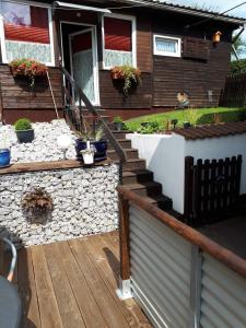 a house with a wooden deck with stairs and a fence at Heidi`s Ferienhaus in Mittenaar