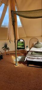 um quarto com uma cama numa tenda em Bell Tent Village em Nottingham