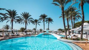 a pool at a resort with palm trees at Hilton Mallorca Galatzo in Paguera