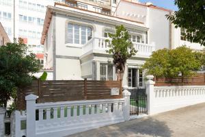 una casa blanca con una valla delante en Adosado con jardín en el centro de A Coruña en A Coruña