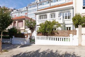 una cerca blanca frente a un edificio blanco en Adosado con jardín en el centro de A Coruña en A Coruña