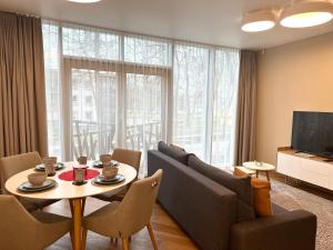 uma sala de estar com uma mesa e cadeiras e uma televisão em SOLEMI em Druskininkai