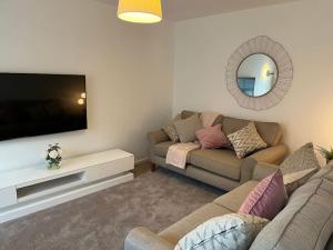 a living room with a couch and a flat screen tv at Cheshire East Detached 3BD, Central home CW1 in Crewe