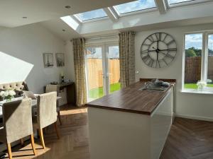 a kitchen with a large clock on the wall at Cheshire East Detached 3BD, Central home CW1 in Crewe