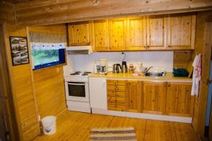 uma cozinha com um fogão branco e armários de madeira em Seterstue i Beiarn - Beiarn Lodge em Beiarn