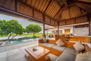 sala de estar al aire libre con sofá y mesa en DeLuxe 2BR Villa + Private pool + Sawa view!, en Tegallengah